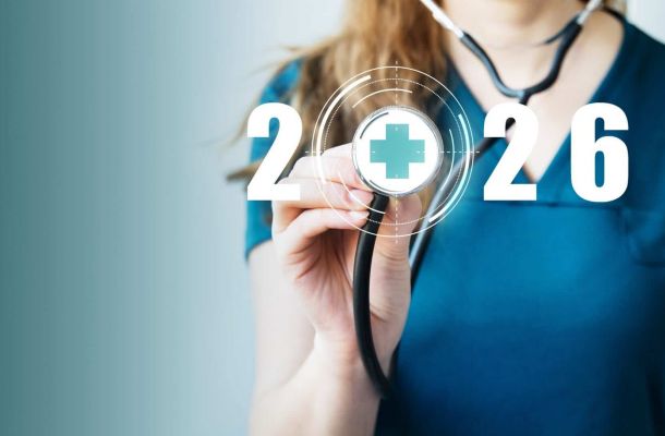Symbolfoto Pflege 2026: Pflegekraft hält Stethoskop mit digitalem Kreuz-Icon und Jahreszahl 2026 im Hintergrund.